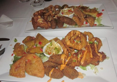Two platters of fried appetizers with Haitian cole slaw.